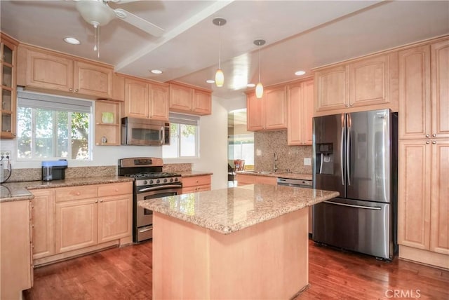 kitchen with hanging light fixtures, light brown cabinets, dark wood-type flooring, and appliances with stainless steel finishes