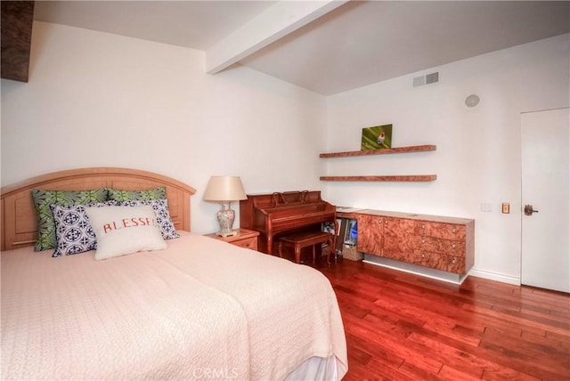 bedroom with beamed ceiling and dark hardwood / wood-style floors