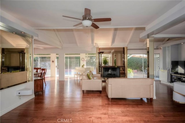 living room with lofted ceiling with beams, hardwood / wood-style floors, ceiling fan, and a healthy amount of sunlight