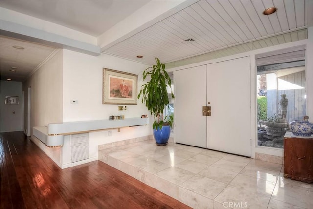 foyer with beamed ceiling, wooden ceiling, and light hardwood / wood-style flooring