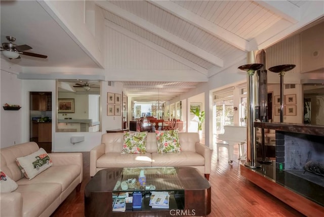 living room featuring hardwood / wood-style flooring, beamed ceiling, and high vaulted ceiling