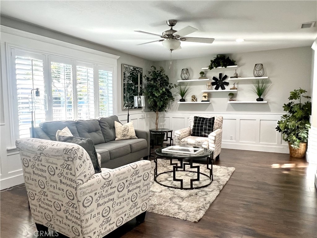 living room featuring ceiling fan and dark wood-type flooring