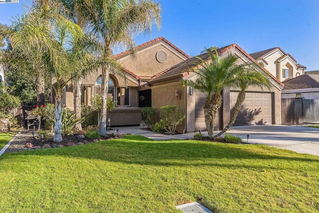 mediterranean / spanish home featuring a front lawn and a garage