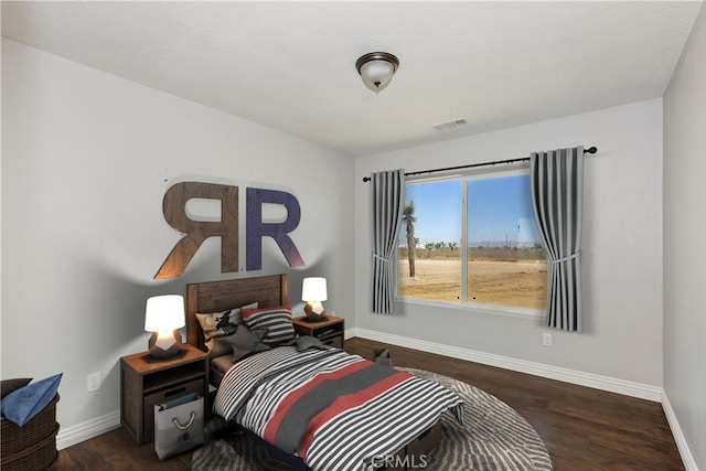 bedroom with dark hardwood / wood-style floors