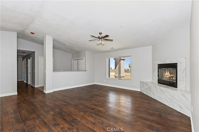 unfurnished living room with dark hardwood / wood-style floors, ceiling fan, lofted ceiling, and a premium fireplace