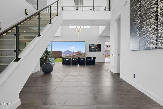 stairway with concrete flooring and a high ceiling