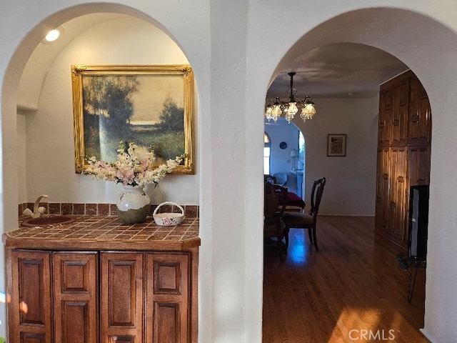 hall featuring hardwood / wood-style floors, sink, and an inviting chandelier