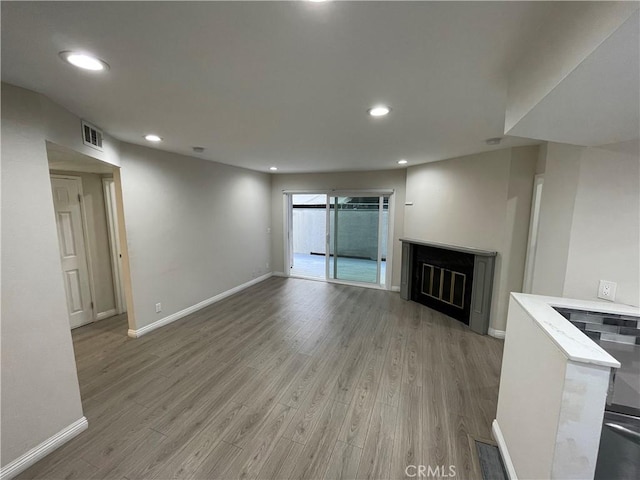 unfurnished living room with a fireplace and light hardwood / wood-style flooring