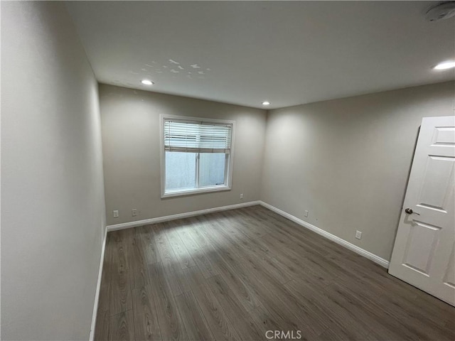 empty room with dark hardwood / wood-style flooring