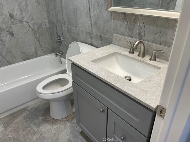 full bathroom with shower / bathing tub combination, vanity, toilet, and tile walls