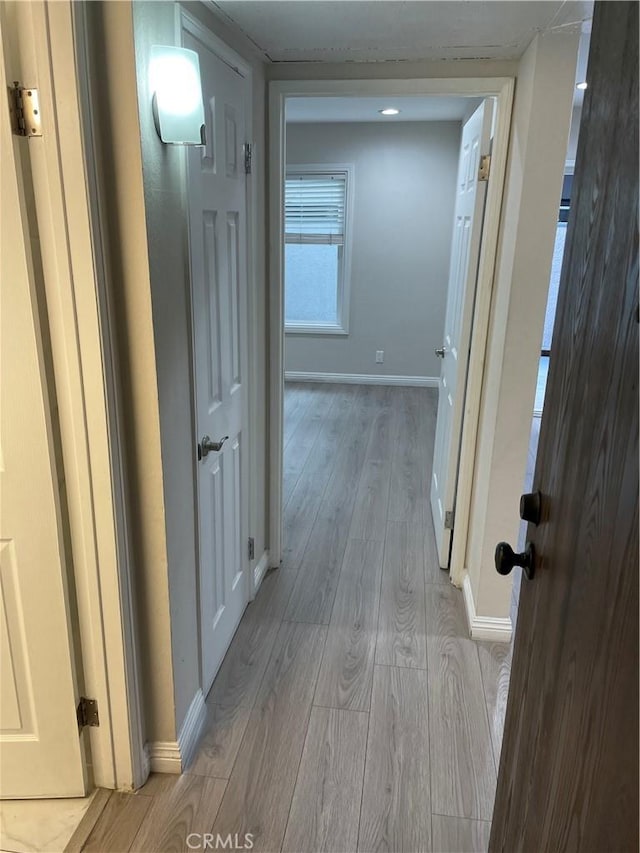 corridor with light hardwood / wood-style flooring