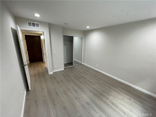 unfurnished bedroom with hardwood / wood-style floors and a closet