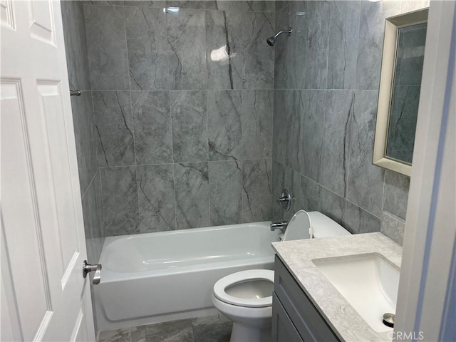 full bathroom featuring vanity, tiled shower / bath combo, toilet, and tile walls