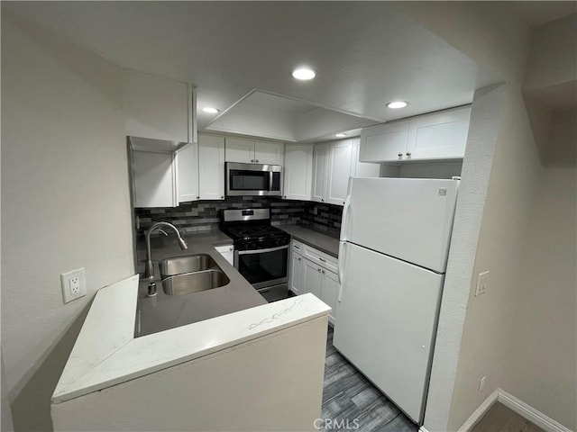 kitchen featuring backsplash, sink, white cabinets, and appliances with stainless steel finishes