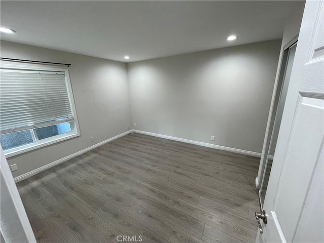 unfurnished room with dark hardwood / wood-style flooring