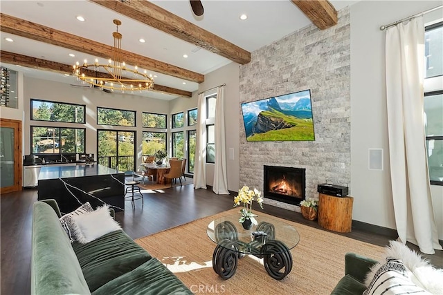 living room featuring hardwood / wood-style floors, a fireplace, beamed ceiling, and a healthy amount of sunlight