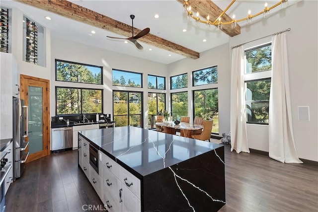 kitchen with a center island, white cabinets, stainless steel appliances, and plenty of natural light