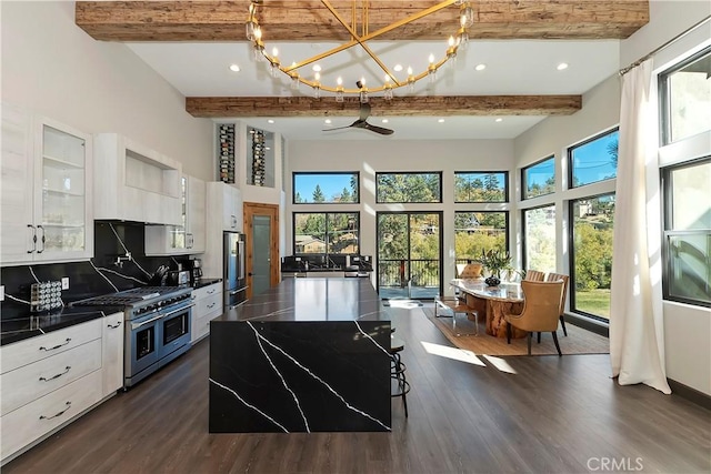 kitchen featuring white cabinets, beam ceiling, and stainless steel appliances