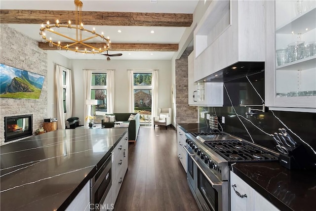 kitchen with white cabinetry, dark hardwood / wood-style floors, pendant lighting, range with two ovens, and a fireplace