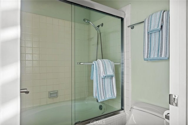 bathroom featuring shower / bath combination with glass door and toilet