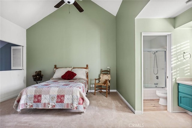 carpeted bedroom featuring ceiling fan, lofted ceiling, and connected bathroom