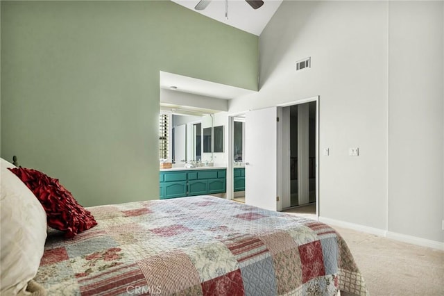 carpeted bedroom with ceiling fan and high vaulted ceiling