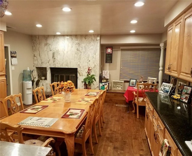 dining area with a high end fireplace and dark hardwood / wood-style flooring