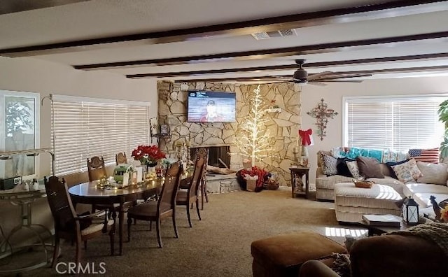 carpeted living room with beam ceiling, ceiling fan, and a fireplace