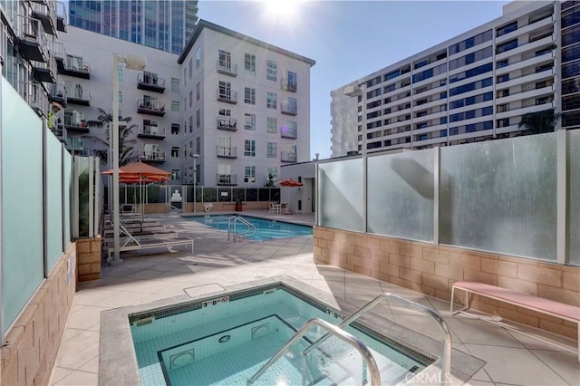 view of pool with a community hot tub and a patio area