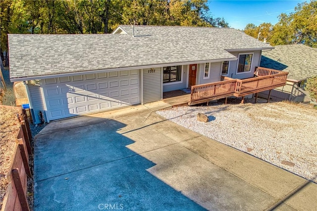 ranch-style home featuring a garage and a wooden deck