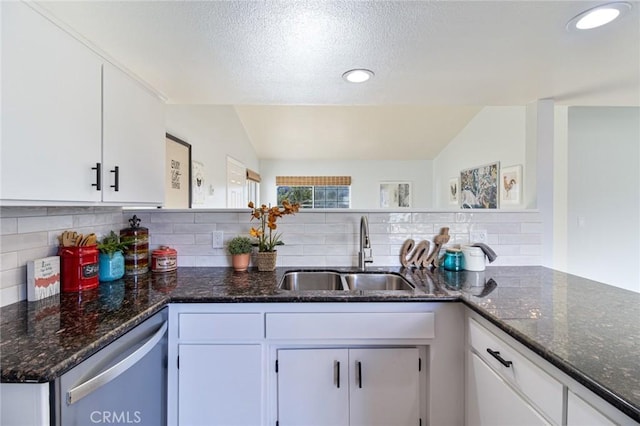 6556 Lupine Ave Unit 29, Palms, CA 92277 - kitchen featuring a sink, stainless steel dishwasher, vaulted ceiling, white cabinetry, and decorative backsplash