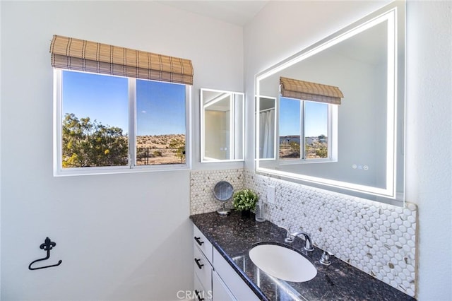 bathroom with vanity, backsplash, and a healthy amount of sunlight