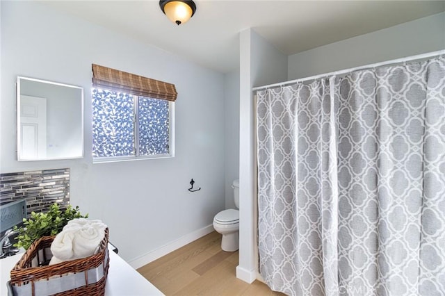 bathroom featuring a shower with shower curtain, wood-type flooring, and toilet