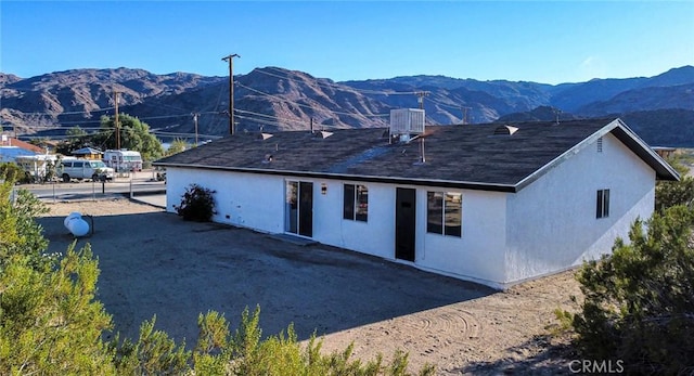 back of house featuring a mountain view and central AC unit