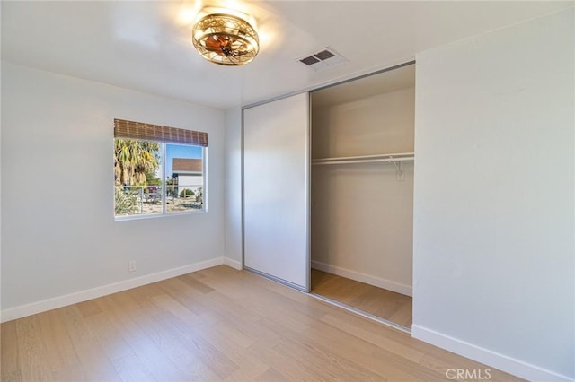 unfurnished bedroom featuring light wood-type flooring and a closet