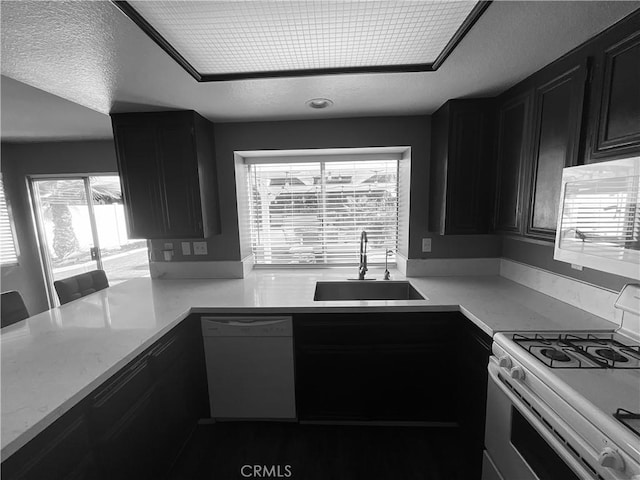 kitchen with a textured ceiling, sink, and white appliances