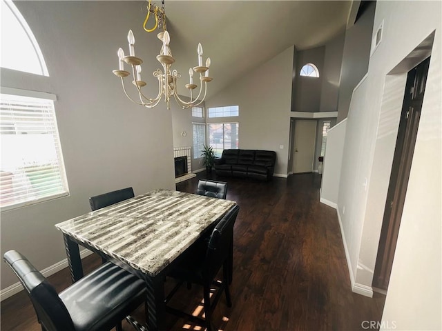 dining room featuring a wealth of natural light, dark hardwood / wood-style flooring, high vaulted ceiling, and a notable chandelier