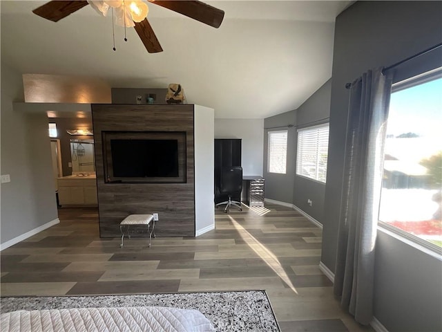 living room featuring a healthy amount of sunlight, lofted ceiling, and hardwood / wood-style flooring