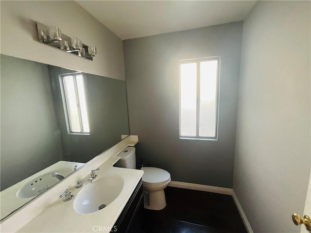 bathroom featuring vanity, toilet, and plenty of natural light