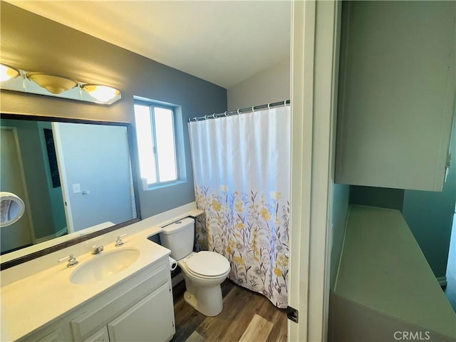 bathroom featuring vanity, hardwood / wood-style floors, toilet, curtained shower, and lofted ceiling