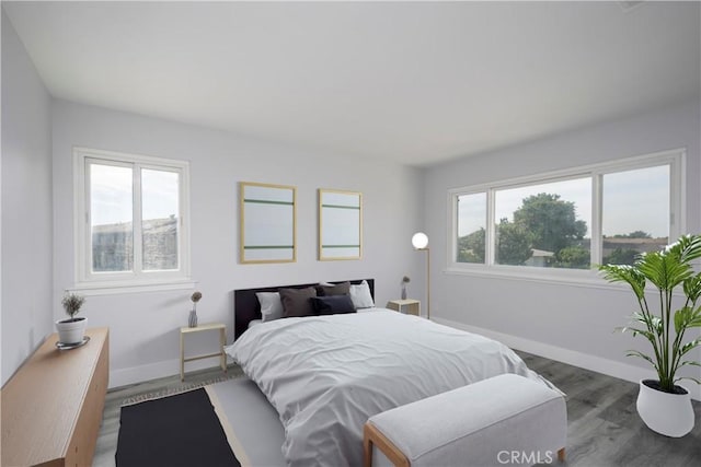 bedroom featuring multiple windows, dark wood finished floors, and baseboards