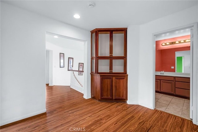 corridor featuring light hardwood / wood-style floors and sink