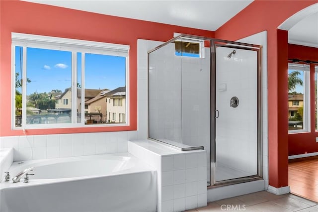 bathroom with tile patterned floors, a healthy amount of sunlight, vaulted ceiling, and shower with separate bathtub