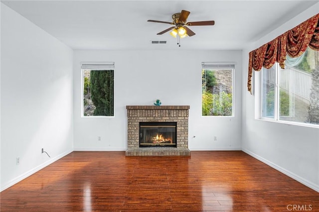 unfurnished living room with hardwood / wood-style floors, ceiling fan, and a fireplace