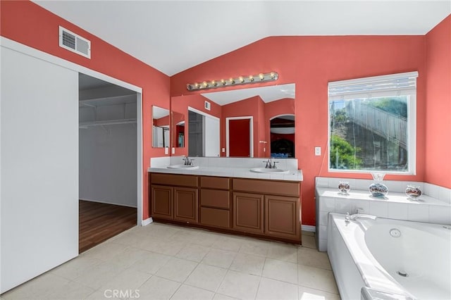 bathroom with a bathing tub, wood-type flooring, vanity, and lofted ceiling