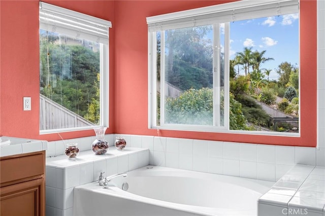 bathroom featuring vanity and tiled bath