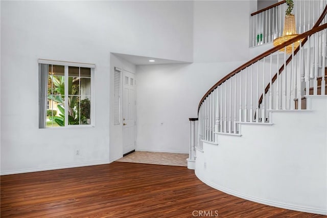 foyer with a towering ceiling and hardwood / wood-style flooring