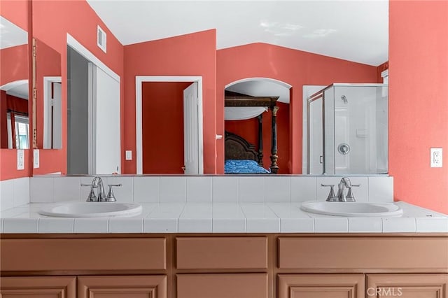 bathroom with vanity, an enclosed shower, and vaulted ceiling