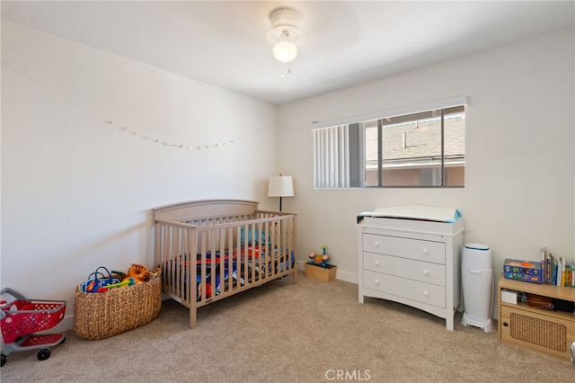 carpeted bedroom featuring a crib