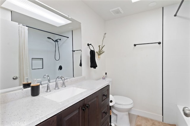 bathroom featuring a tile shower, vanity, toilet, and tile patterned floors